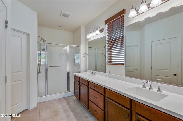 bathroom with walk in shower, vanity, and tile patterned flooring