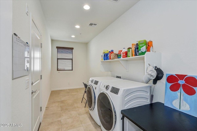 laundry area featuring light tile patterned floors and washing machine and dryer