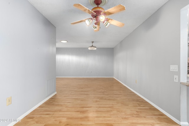 empty room featuring ceiling fan and light hardwood / wood-style floors