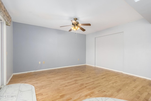 interior space with a skylight, light hardwood / wood-style flooring, and ceiling fan