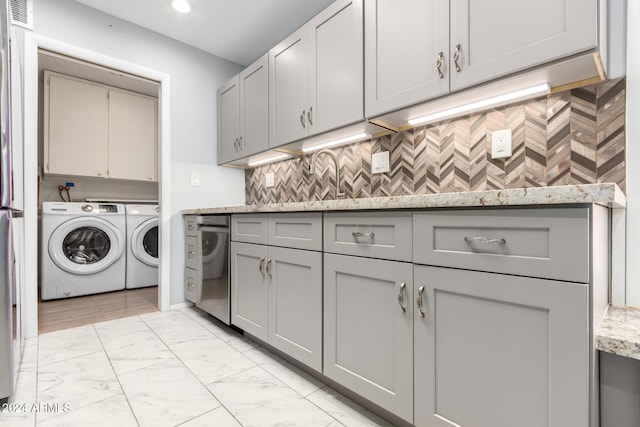 washroom featuring cabinets, washing machine and dryer, and sink