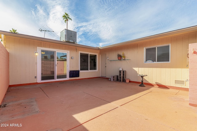 rear view of property with central AC and a patio area