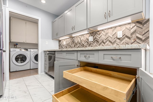 laundry room with washer and clothes dryer, cabinets, and sink