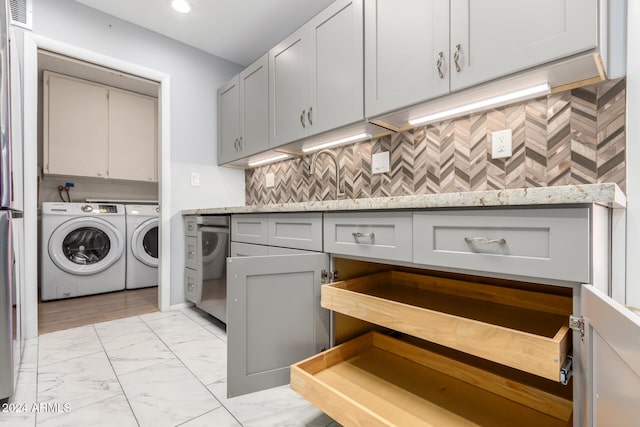 laundry area featuring cabinets, washer and clothes dryer, and sink