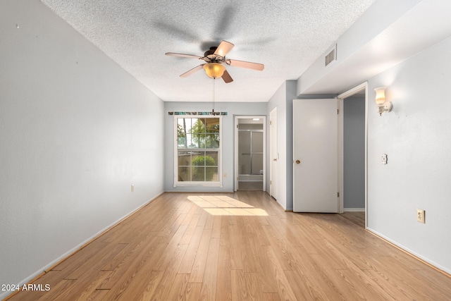 empty room featuring ceiling fan, a textured ceiling, and light hardwood / wood-style flooring