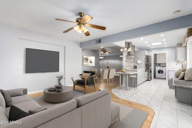 living room with ceiling fan and washer / dryer