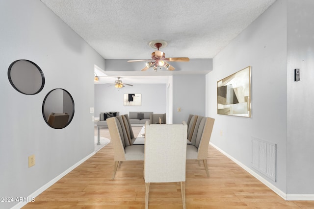 dining area featuring a textured ceiling and light wood-type flooring