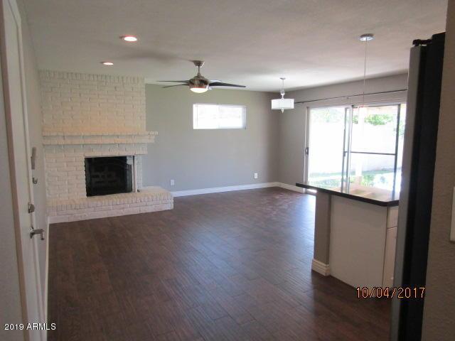 327 E Ln Jolla Dr, Tempe, AZ 85282 - unfurnished living room with baseboards, dark wood finished floors, ceiling fan, a brick fireplace, and recessed lighting
