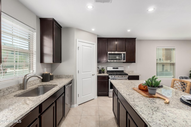 8208 W Albeniz Pl, Phoenix, AZ 85043 - kitchen featuring appliances with stainless steel finishes, a sink, dark brown cabinetry, recessed lighting, and light stone counters