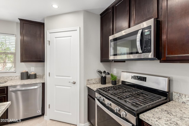8208 W Albeniz Pl, Phoenix, AZ 85043 - kitchen featuring stainless steel appliances, dark brown cabinetry, light stone counters, light tile patterned floors, and recessed lighting