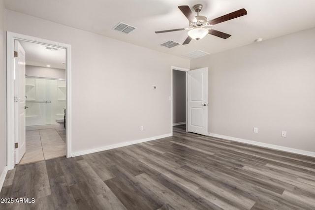 8208 W Albeniz Pl, Phoenix, AZ 85043 - unfurnished bedroom featuring baseboards, dark wood-style flooring, and connected bathroom