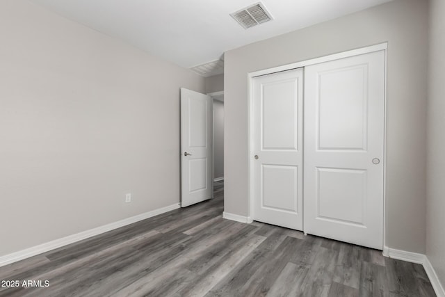 8208 W Albeniz Pl, Phoenix, AZ 85043 - unfurnished bedroom with wood finished floors, baseboards, and a closet