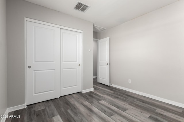 8208 W Albeniz Pl, Phoenix, AZ 85043 - unfurnished bedroom with wood finished floors, baseboards, and a closet