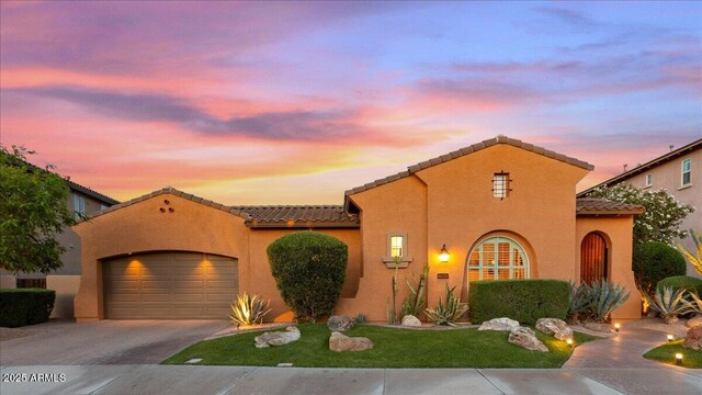 25943 N 84th Dr, Peoria, AZ 85383 - mediterranean / spanish home featuring an attached garage, stucco siding, a tiled roof, and driveway