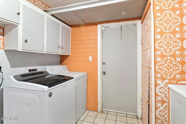 laundry area with cabinets, washing machine and dryer, and light tile patterned flooring