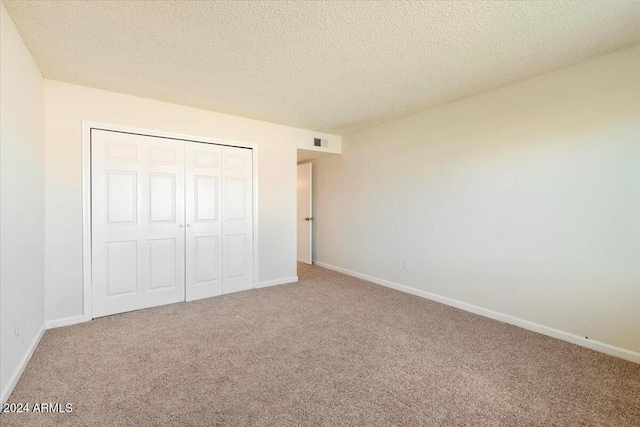 unfurnished bedroom with a closet, a textured ceiling, and carpet flooring