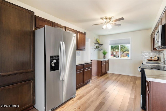 kitchen with decorative backsplash, sink, ceiling fan, light wood-type flooring, and appliances with stainless steel finishes