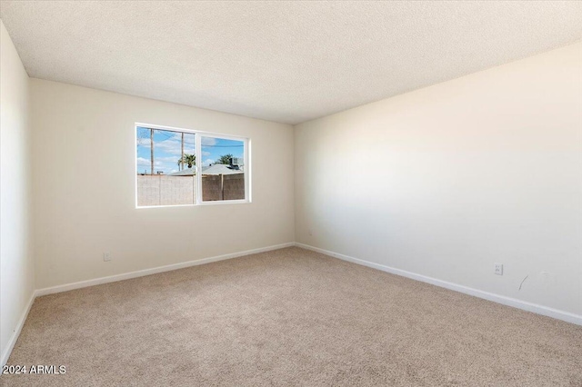 carpeted empty room with a textured ceiling