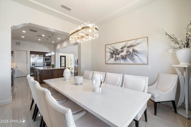 dining room with a notable chandelier and light wood-type flooring