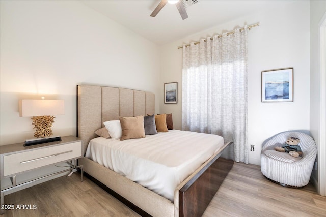 bedroom featuring ceiling fan, light hardwood / wood-style floors, and vaulted ceiling