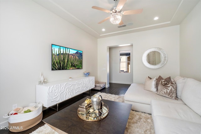 living room with a raised ceiling, ceiling fan, and hardwood / wood-style flooring