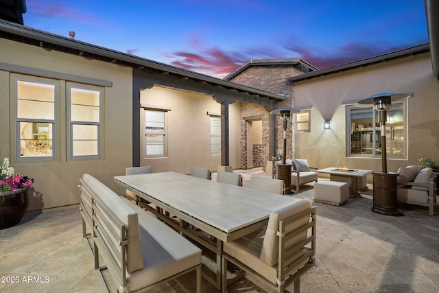 patio terrace at dusk featuring a fire pit