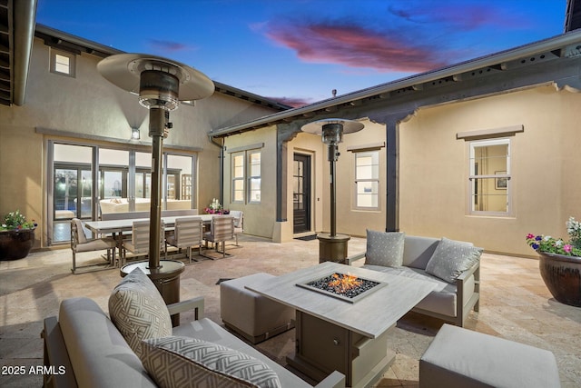 patio terrace at dusk featuring an outdoor living space with a fire pit