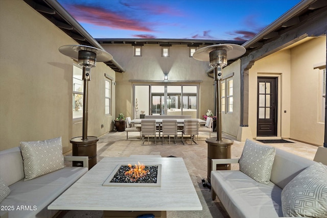 patio terrace at dusk featuring an outdoor living space with a fire pit