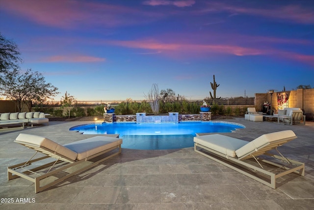 pool at dusk featuring a patio area and pool water feature