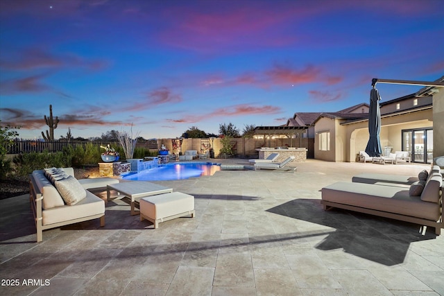 pool at dusk featuring pool water feature and a patio