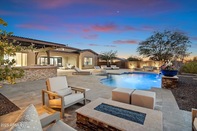 pool at dusk featuring an outdoor living space with a fire pit, pool water feature, and a patio