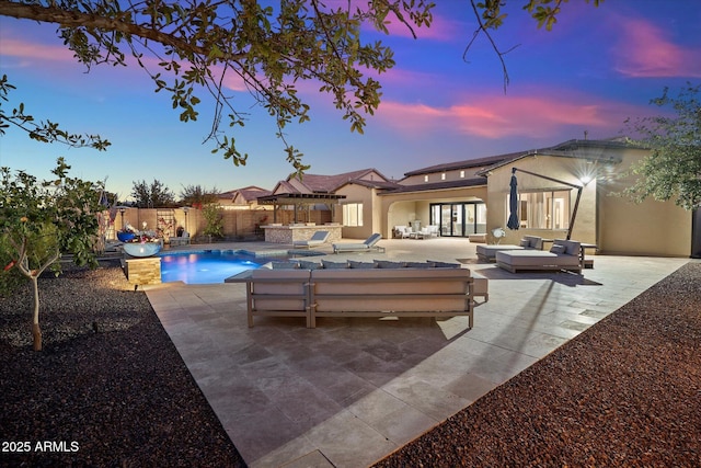 pool at dusk with outdoor lounge area and a patio area