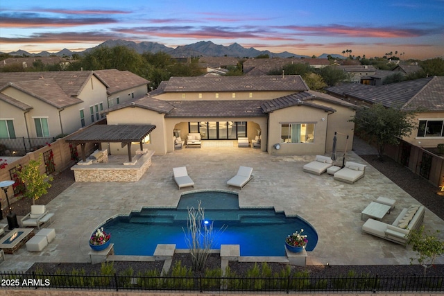 pool at dusk with a mountain view and a patio