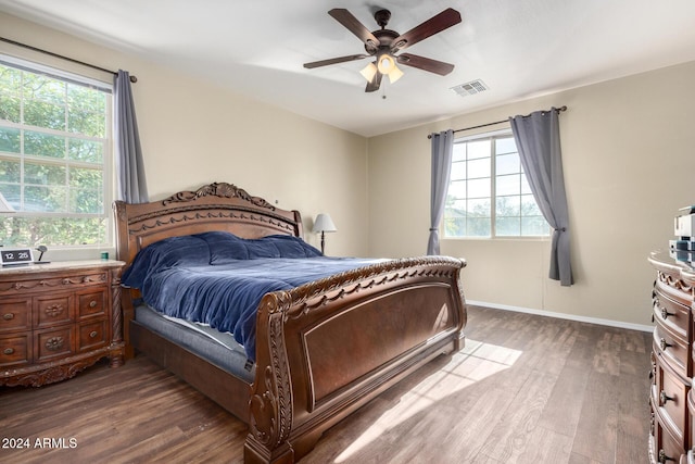 bedroom featuring multiple windows, ceiling fan, and dark wood-type flooring