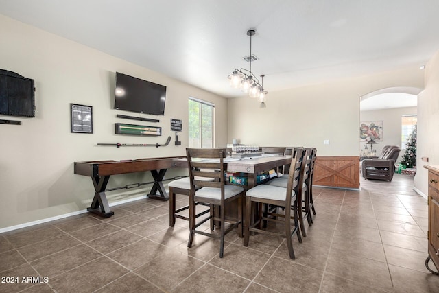 tiled dining room featuring a notable chandelier