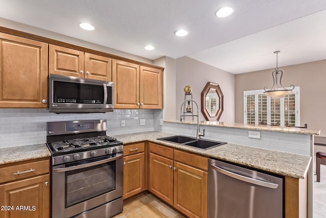 kitchen featuring light stone counters, sink, kitchen peninsula, stainless steel appliances, and decorative backsplash