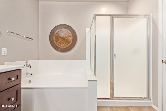 bathroom featuring tile patterned flooring, vanity, and plus walk in shower