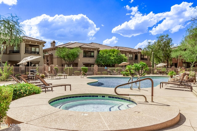 view of swimming pool featuring a patio and a hot tub