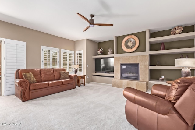 living room featuring ceiling fan, light colored carpet, and a fireplace