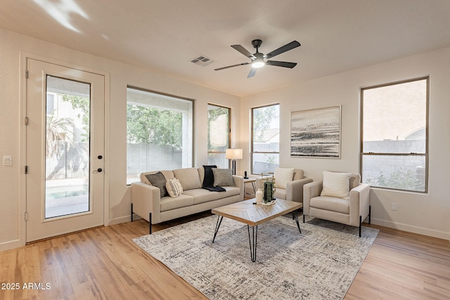 living room featuring light hardwood / wood-style flooring and ceiling fan