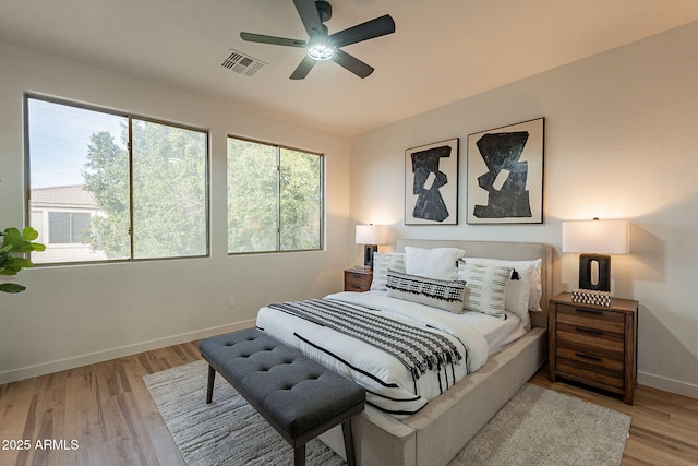 bedroom with multiple windows, wood-type flooring, and ceiling fan