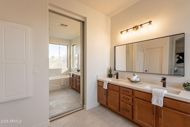 bathroom featuring vanity, a bathing tub, and tile patterned flooring