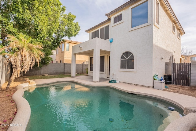 rear view of house featuring a fenced in pool, a patio, a balcony, and central air condition unit