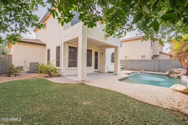 back of house featuring a fenced in pool, cooling unit, a patio area, and a lawn