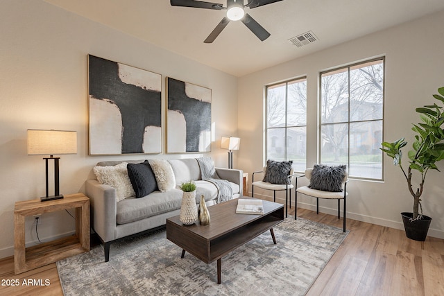 living room with ceiling fan, plenty of natural light, and hardwood / wood-style floors