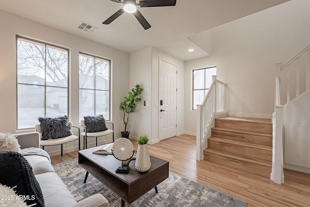 living room with light hardwood / wood-style flooring and ceiling fan