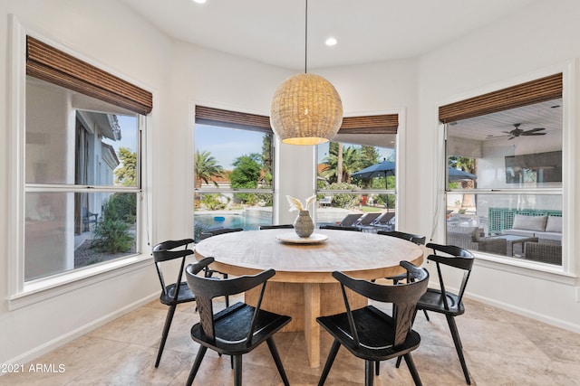 tiled dining area with ceiling fan and a wealth of natural light