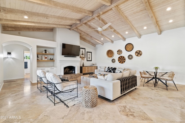 living room featuring ceiling fan, built in shelves, beam ceiling, high vaulted ceiling, and wooden ceiling