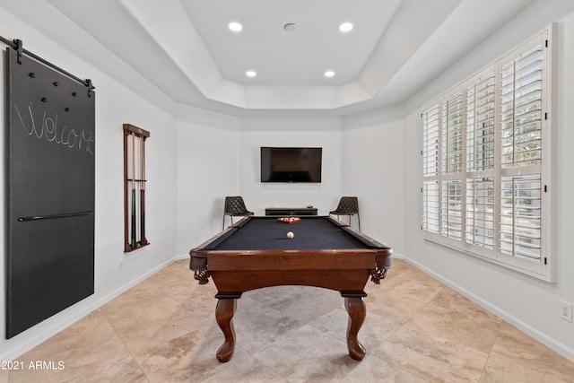 playroom with pool table, a tray ceiling, and a barn door