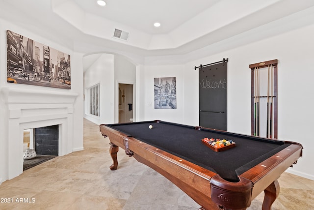 playroom with pool table, a tray ceiling, and a barn door